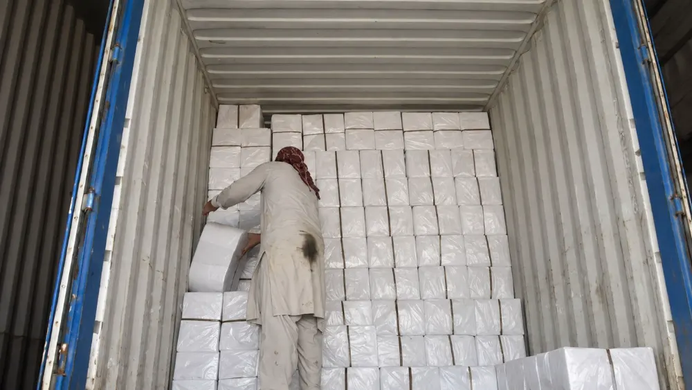 Team loading boxed goods into a shipping container